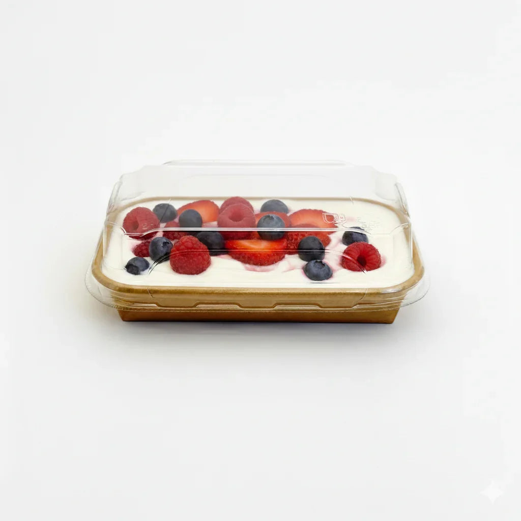 Square dessert with berries in a tray with clear lid on a white background