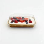 Square dessert with berries in a tray with clear lid on a white background