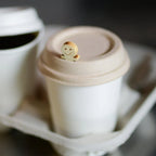 White compostable cup with a lid featuring a wooden plug on a blurred background